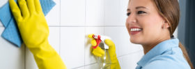 woman cleaning tile wall