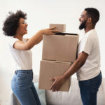 Happy Couple Packing Moving Boxes Together